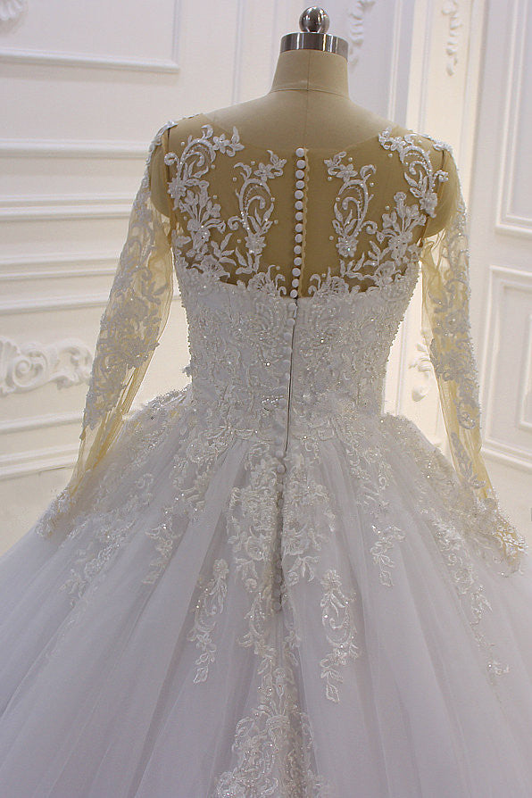 Hermoso vestido de novia largo de corte A con escote barco, apliques de tul perlado y encaje con mangas