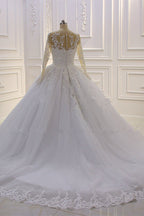Hermoso vestido de novia largo de corte A con escote barco, apliques de tul perlado y encaje con mangas