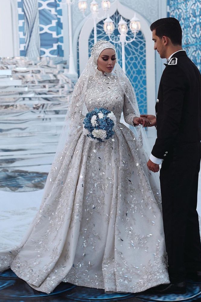 Hermoso vestido de novia con lentejuelas, mangas largas, cuello alto y cola larga