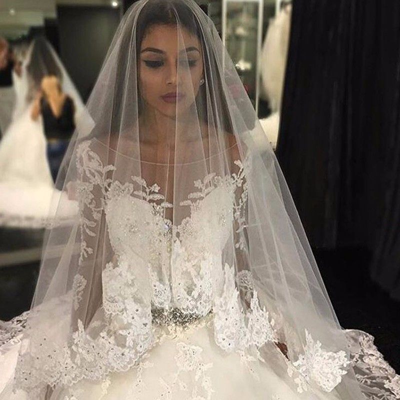 Hermoso vestido de novia con apliques de tul, mangas largas y escote redondo y cristales