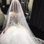 Hermoso vestido de novia con apliques de tul, mangas largas y escote redondo y cristales