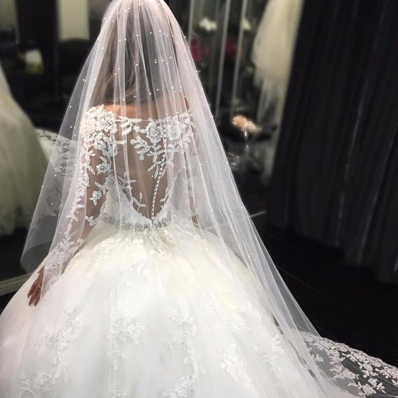 Hermoso vestido de novia con apliques de tul, mangas largas y escote redondo y cristales