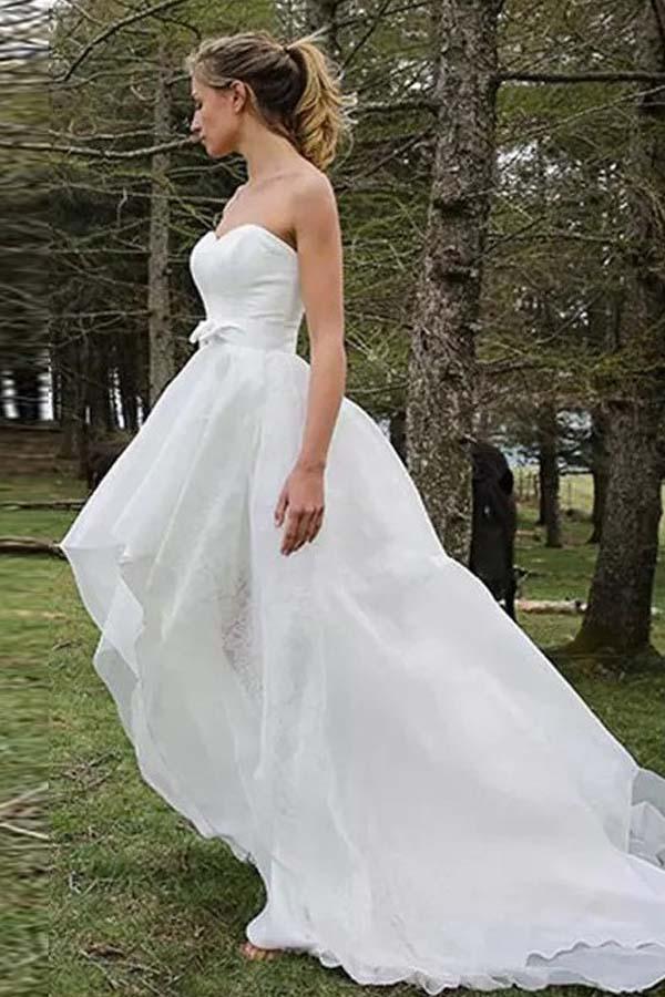 Vestido de novia de organza con apliques y escote corazón, sin mangas y corte alto bajo 