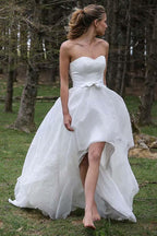 Vestido de novia de organza con apliques y escote corazón, sin mangas y corte alto bajo 