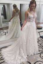 Vestidos de novia de encaje color marfil con apliques transparentes y cola de corte