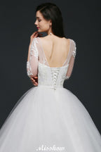 Robe de mariée en tulle à jupe bouffante avec applications en dentelle et encolure dégagée