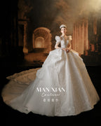 Abito da sposa regale con maniche a sbuffo, perline, gonna a palloncino, strascico a cattedrale e schiena a effetto vedo