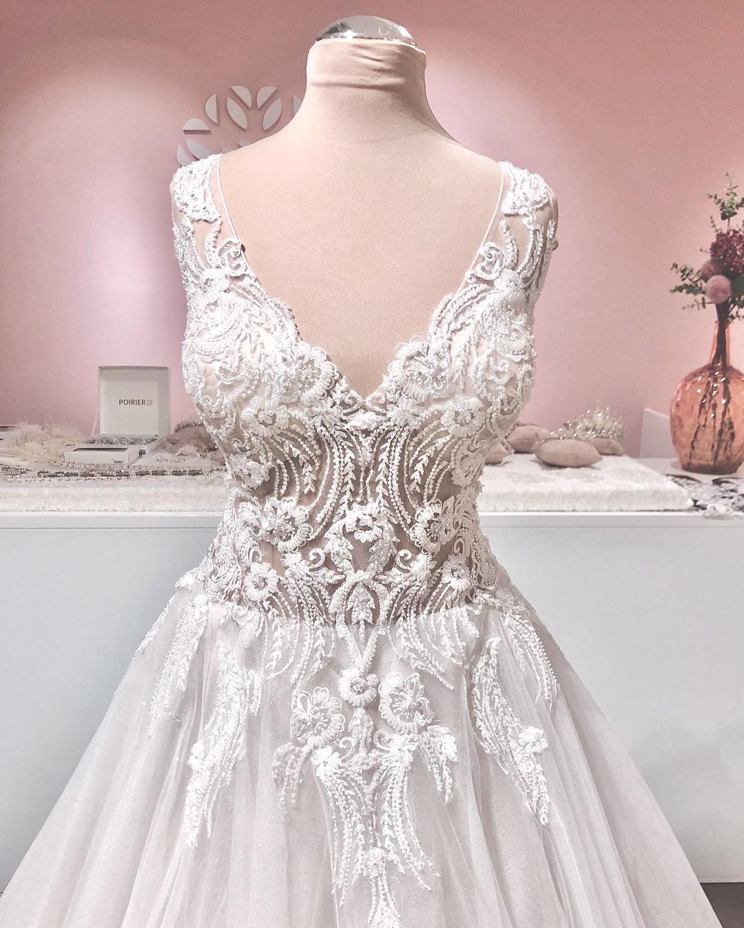 Vestido de noiva longo em linha A com decote em V, apliques de renda, costas descobertas, tule e folhos