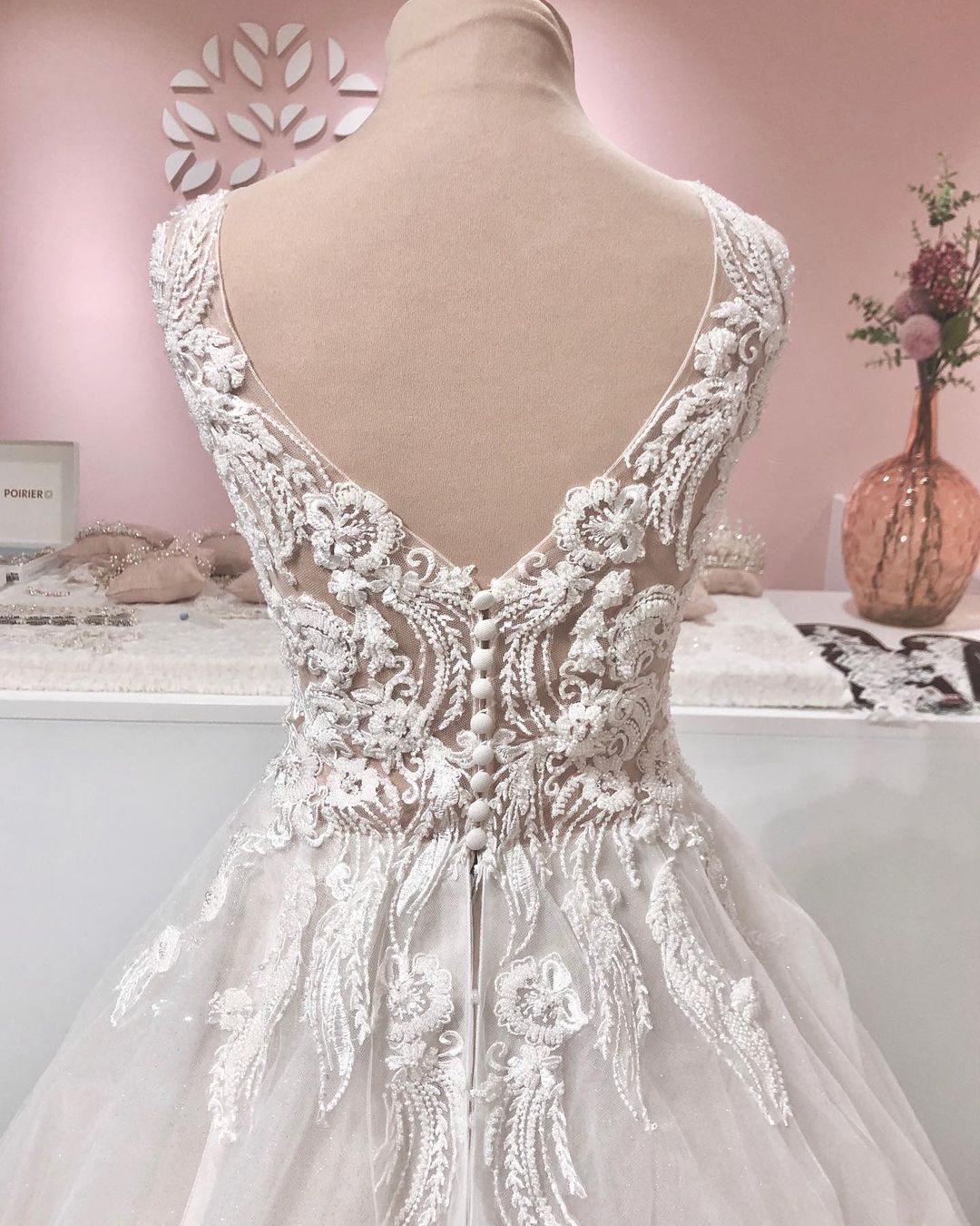 Vestido de noiva longo em linha A com decote em V, apliques de renda, costas descobertas, tule e folhos