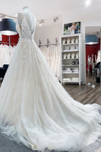 Vestido de noiva longo em linha A com decote em V, alças finas e costas em renda de tule sem costas