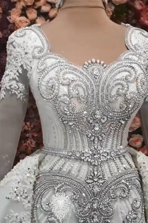 Lujoso vestido de novia de corte A con mangas largas, cuentas y cola