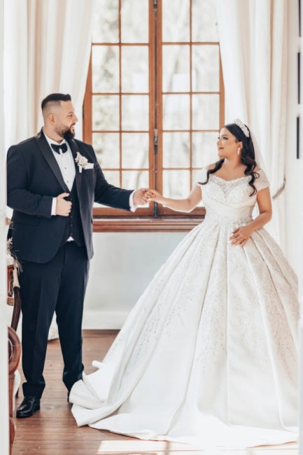 Lujoso vestido de novia blanco largo de satén con hombros descubiertos y encaje.