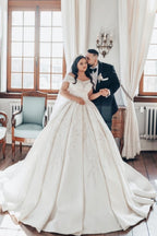 Lujoso vestido de novia blanco largo de satén con hombros descubiertos y encaje.