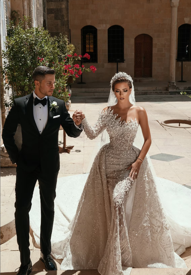 Abito da sposa lungo bianco lussuoso con una spalla, linea a trapezio, perline ricamate, maniche lunghe e strascico