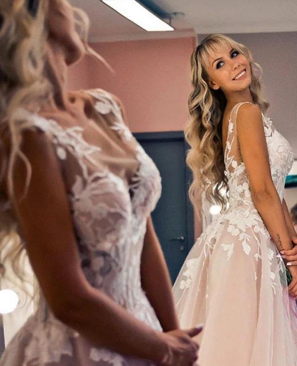 Vestido de noiva de corte A com aplicação de renda aberta em tule com decote em V e cauda de capela