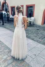Vestido de novia sencillo de tul blanco con escote halter y sin mangas en forma de A