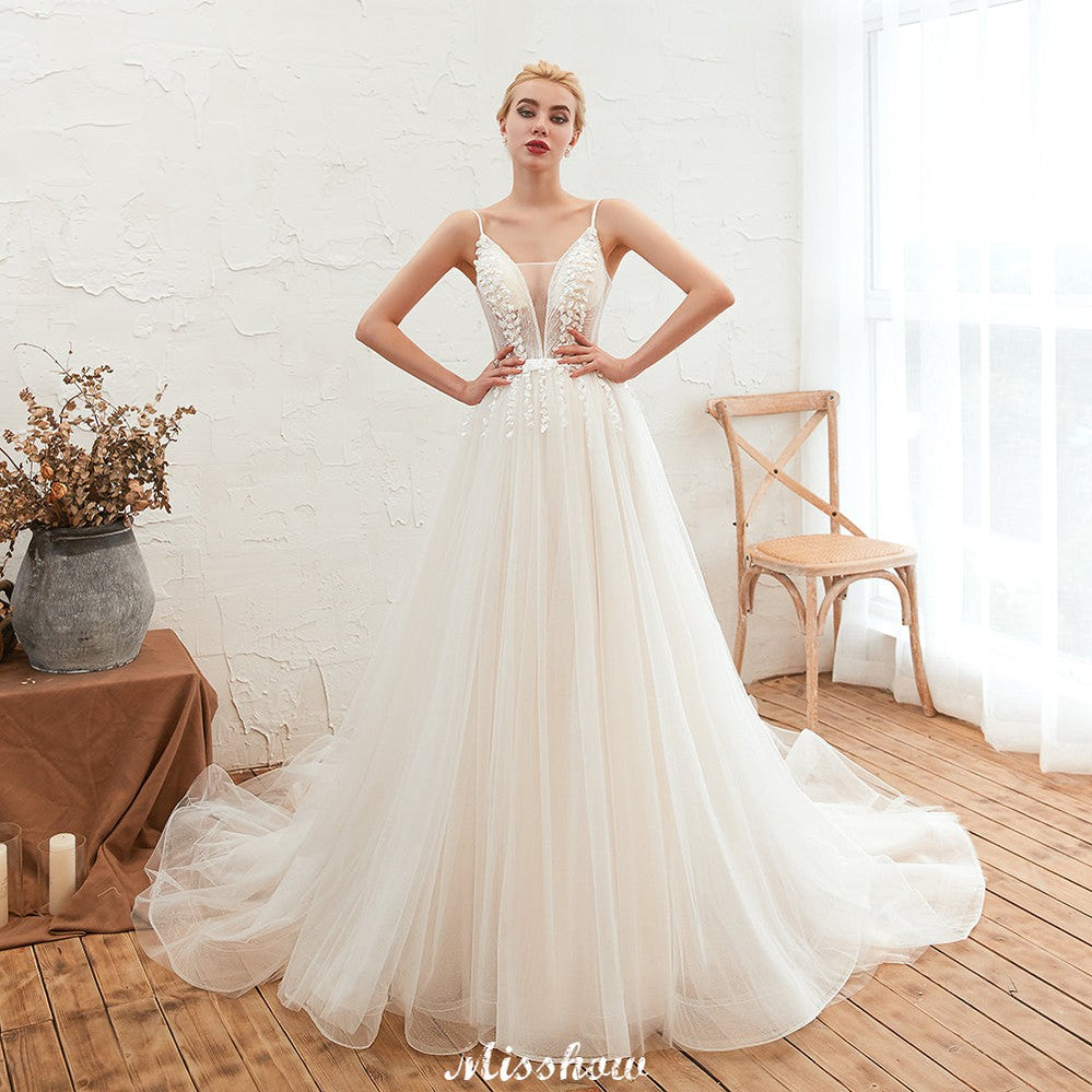 Robe de mariée champagne à fines bretelles, décolleté en V plongeant et dos nu